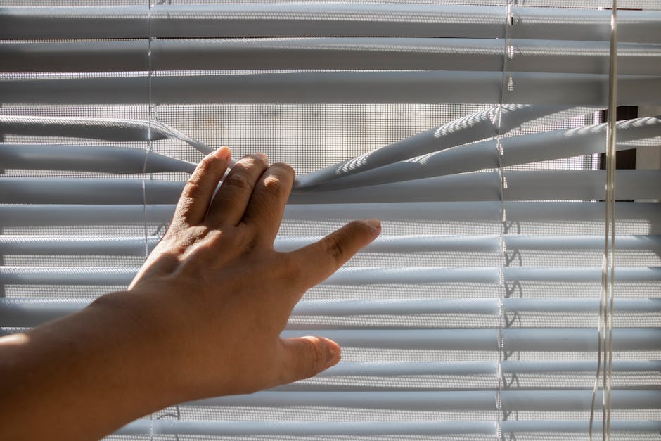Professional installer fitting custom window blinds in a residential home